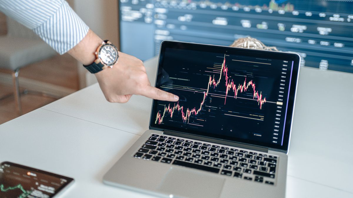 A hand pointing at a rising performance chart on a laptop screen, representing proving the ROI of a Claude Code build to a client.