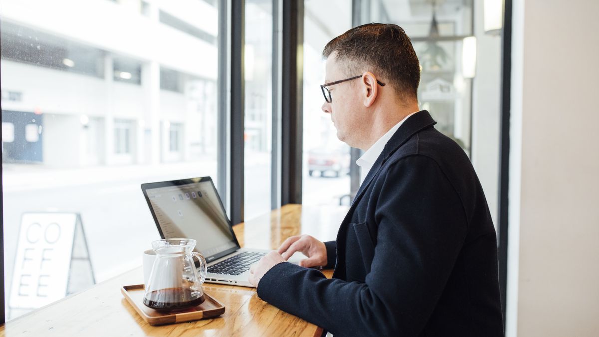 A builder in a coffee shop working on a laptop, representing small Claude Code builds you can scope and sell inside a week.