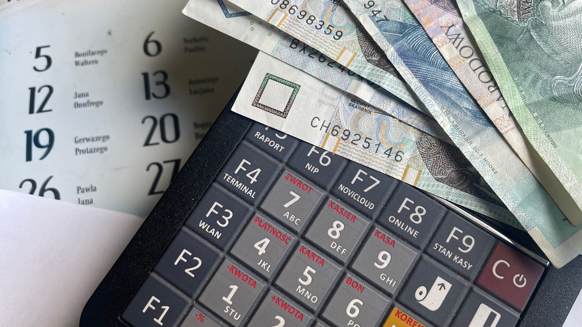 A calculator and banknotes resting on a calendar, representing structuring client payments across scheduled milestones.